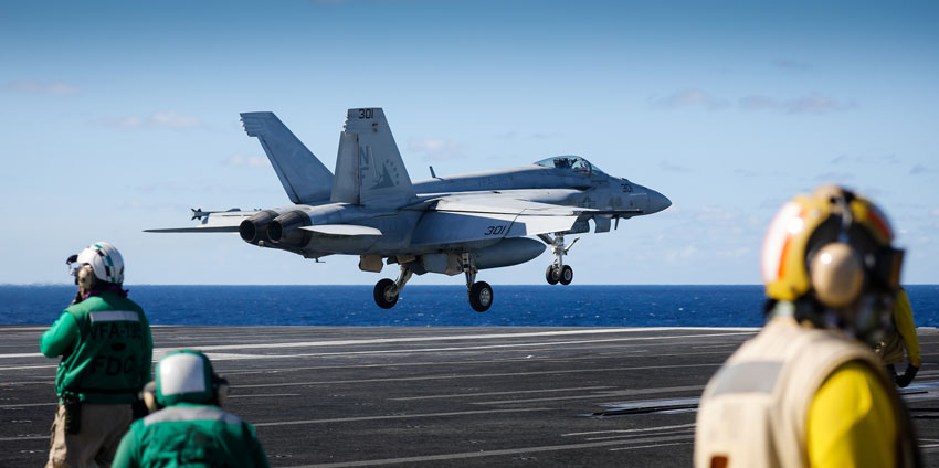 military personnel wearing hearing protection on aircraft carrier