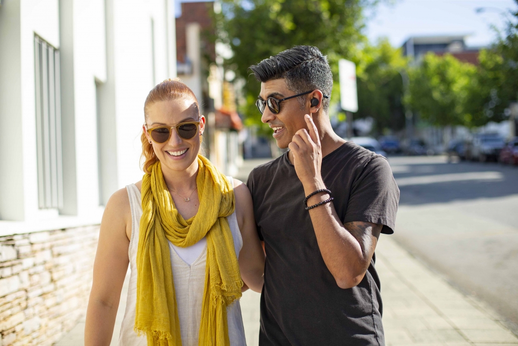 Nuheara hearing device in use on a city sidewalk